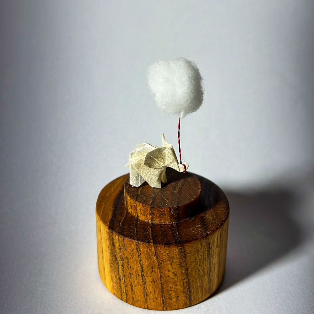 Lámpara miniatura de elefante amarillo en origami sosteniendo una nube iluminada en domo de vidrio - Plicatorius.