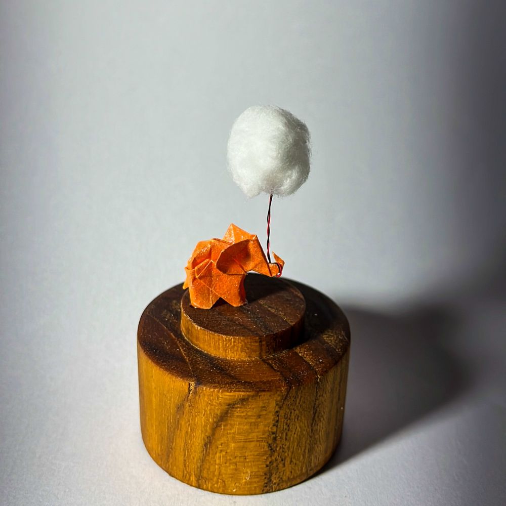 Lámpara miniatura de elefante amarillo en origami sosteniendo una nube iluminada en domo de vidrio - Plicatorius.