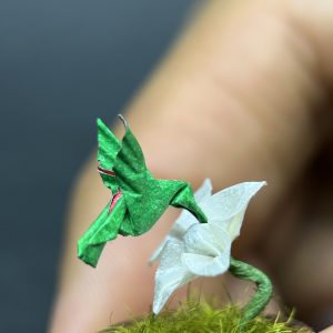 Colibrí verde en origami sobre flor amarilla miniatura en cúpula de vidrio - Artesanía Plicatorius Colombia.