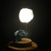 Lámpara miniatura de elefante amarillo en origami sosteniendo una nube iluminada en domo de vidrio - Plicatorius.