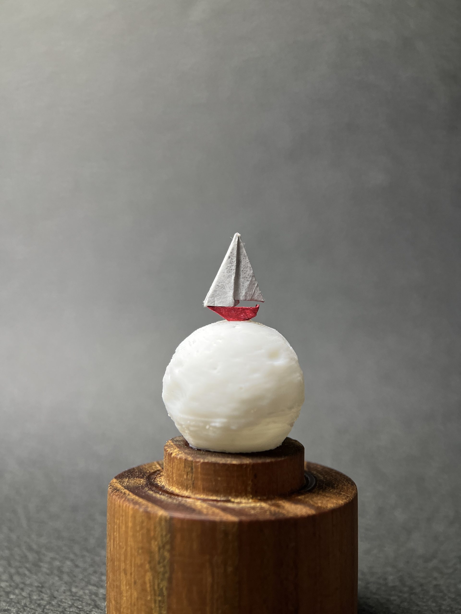 Barco de papel en origami sobre la luna miniatura en domo de vidrio y base de teca - Plicatorius.