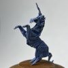 Unicornio de origami miniatura sobe base de madera